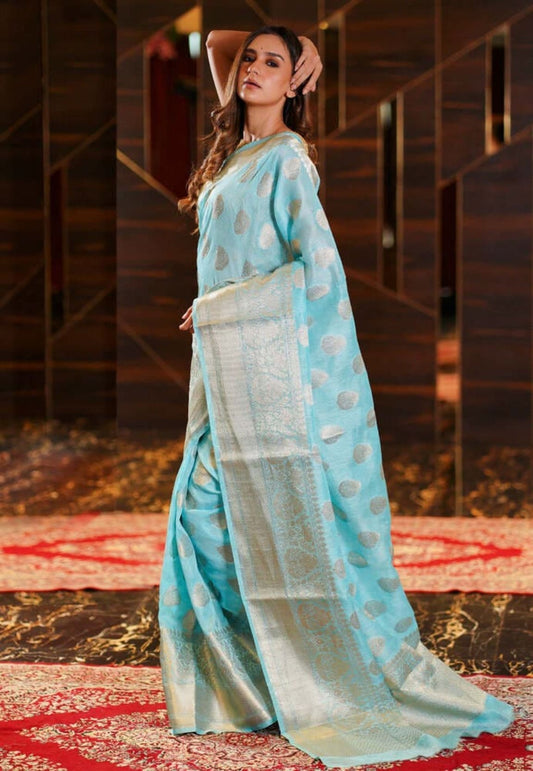 Aqua blue linen saree with gold dot motifs and shimmering zari pallu border