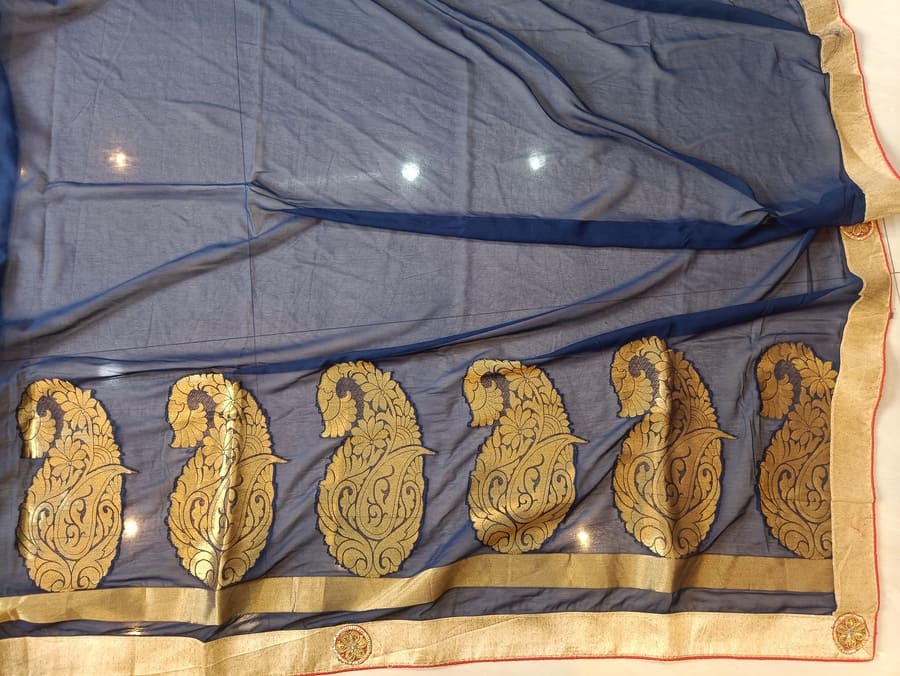 Blue chiffon saree folded with gold paisley design and gold trim
