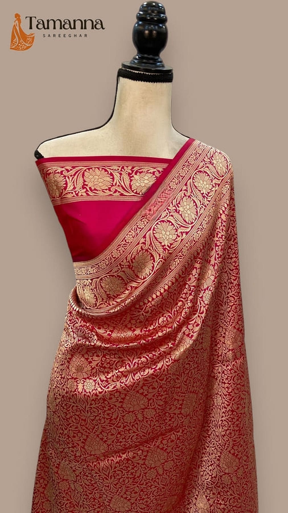 Cherry red silk Banarasi saree with gold-toned border and ornate woven pallu on mannequin