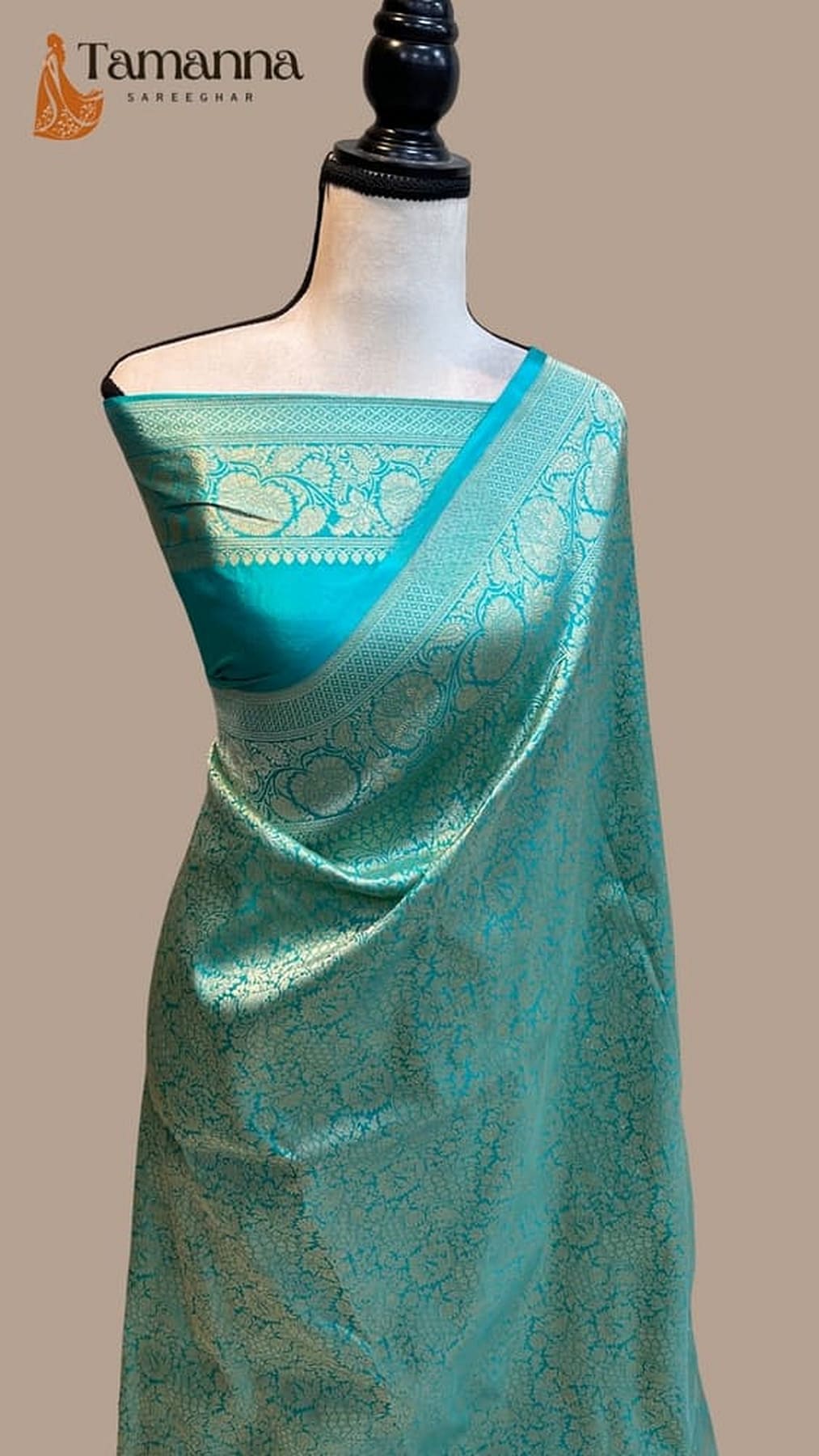 Teal Banarasi silk saree with gold zari trim, draped pallu, and woven motifs