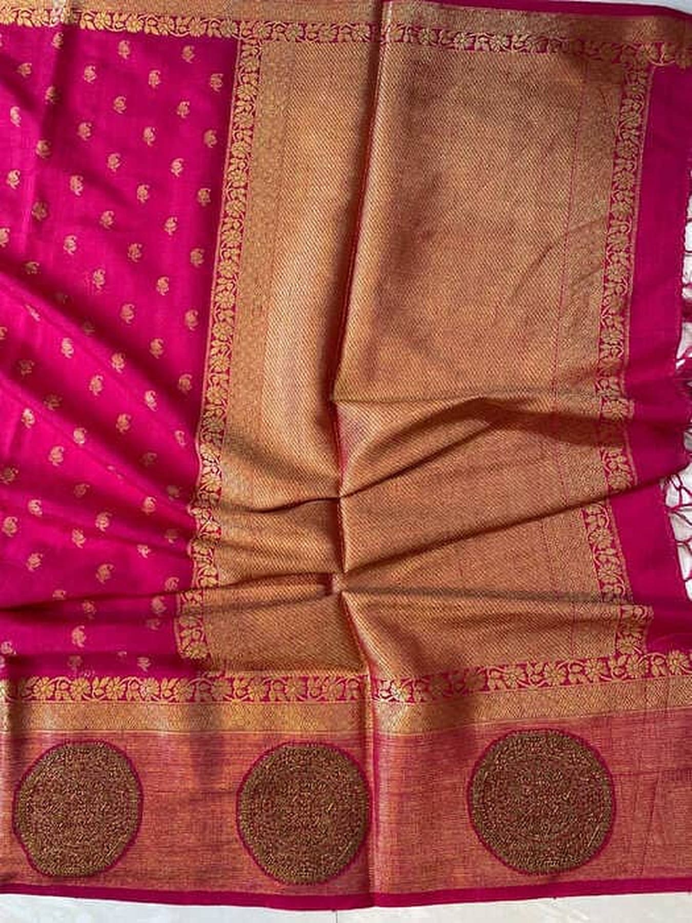 Pink silk saree close-up: gold zari border and three round woven motifs