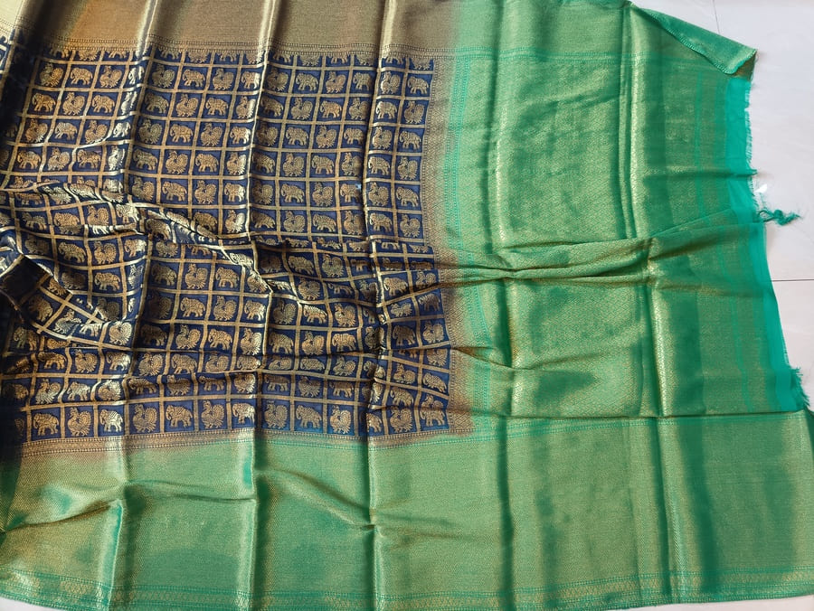 Navy saree with gold zari weave pattern and prominent green border panel on end