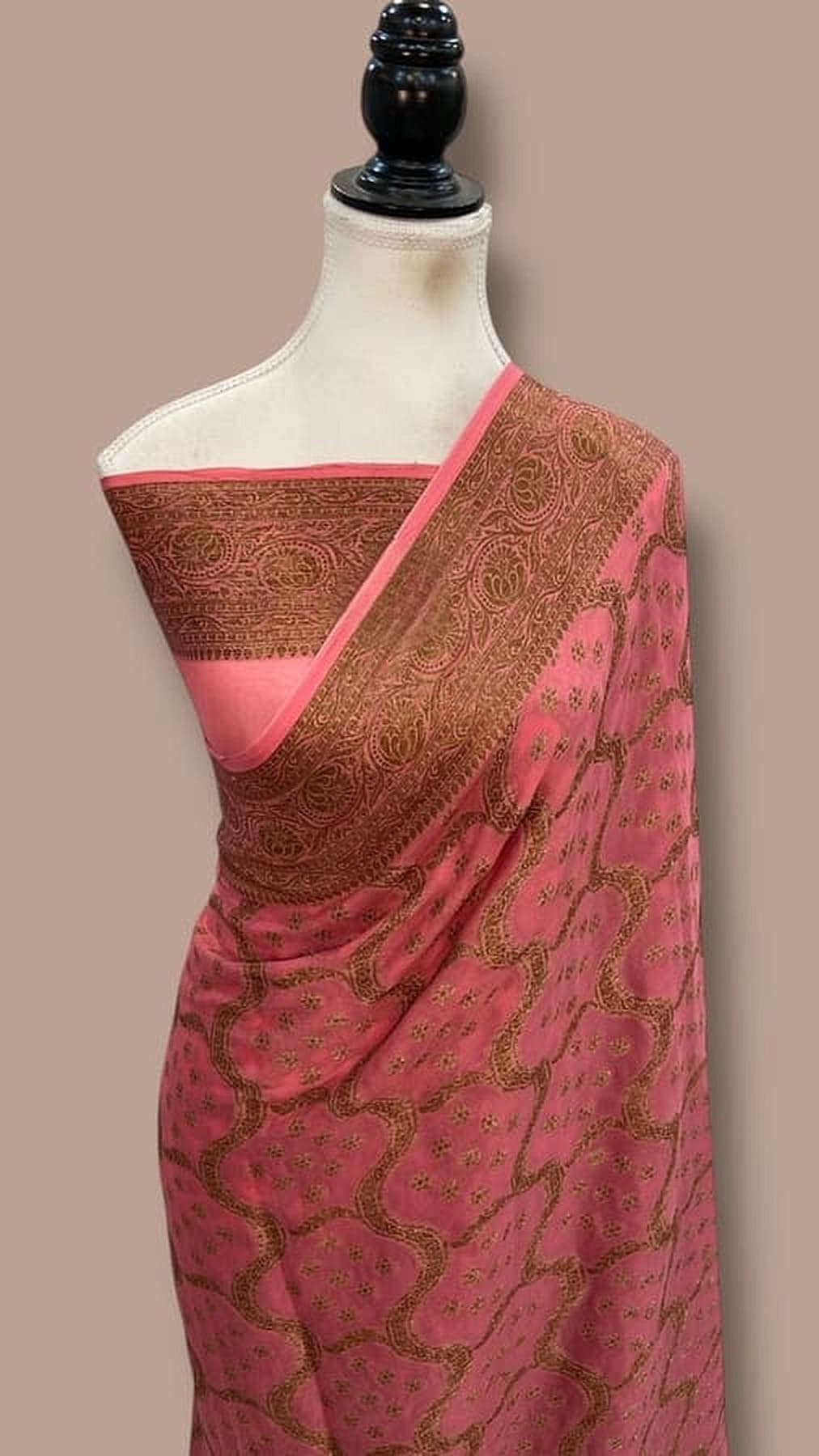 Pink chiffon Banarasi saree with gold-brown zari border, draped on mannequin