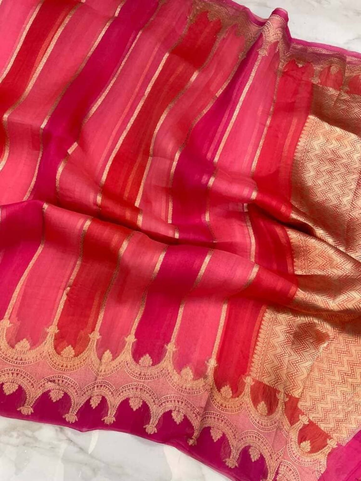 Pink Banarasi saree border close-up, gold zari motifs and striped panel