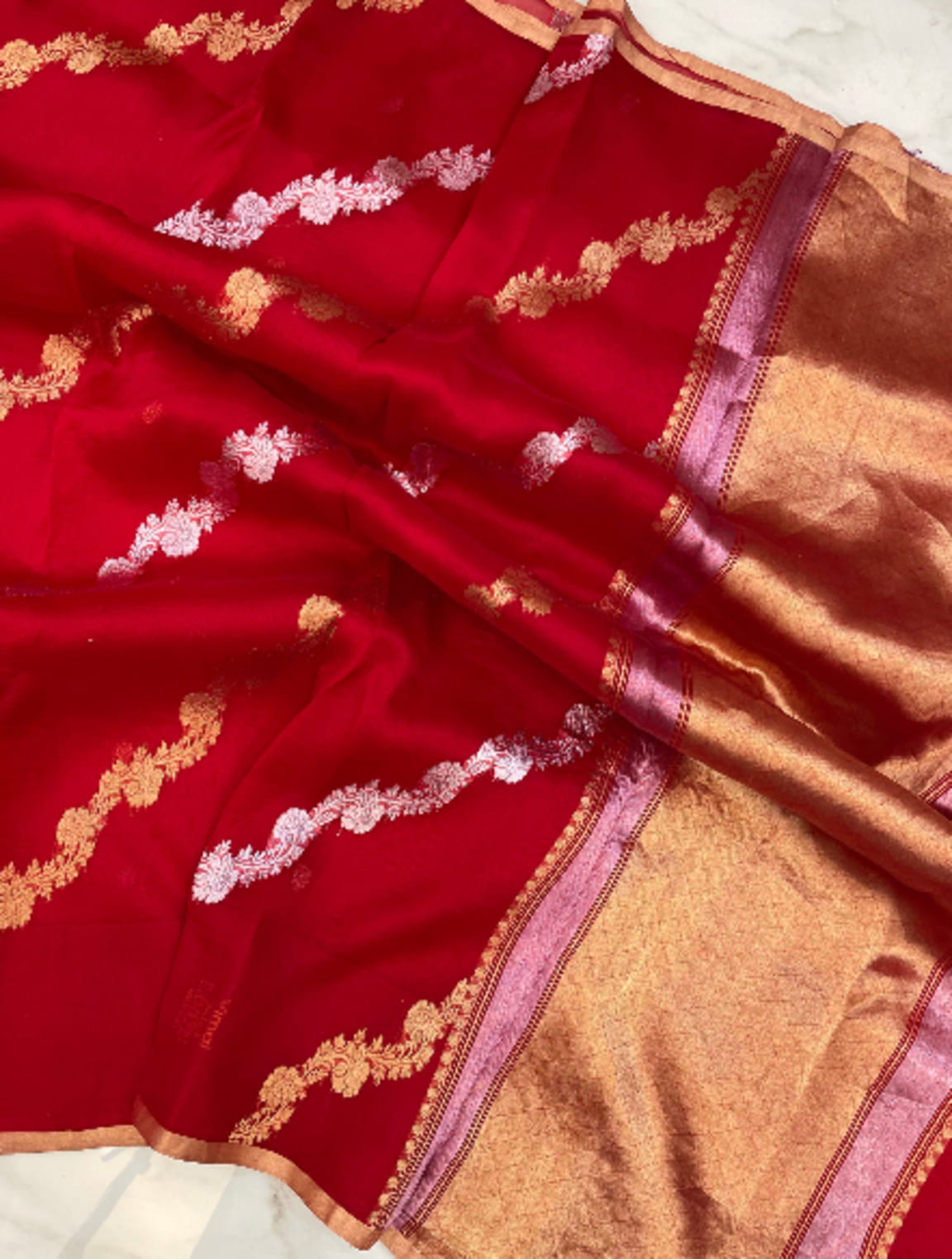 Red saree close-up with gold-silver zari stripes and beige contrast border