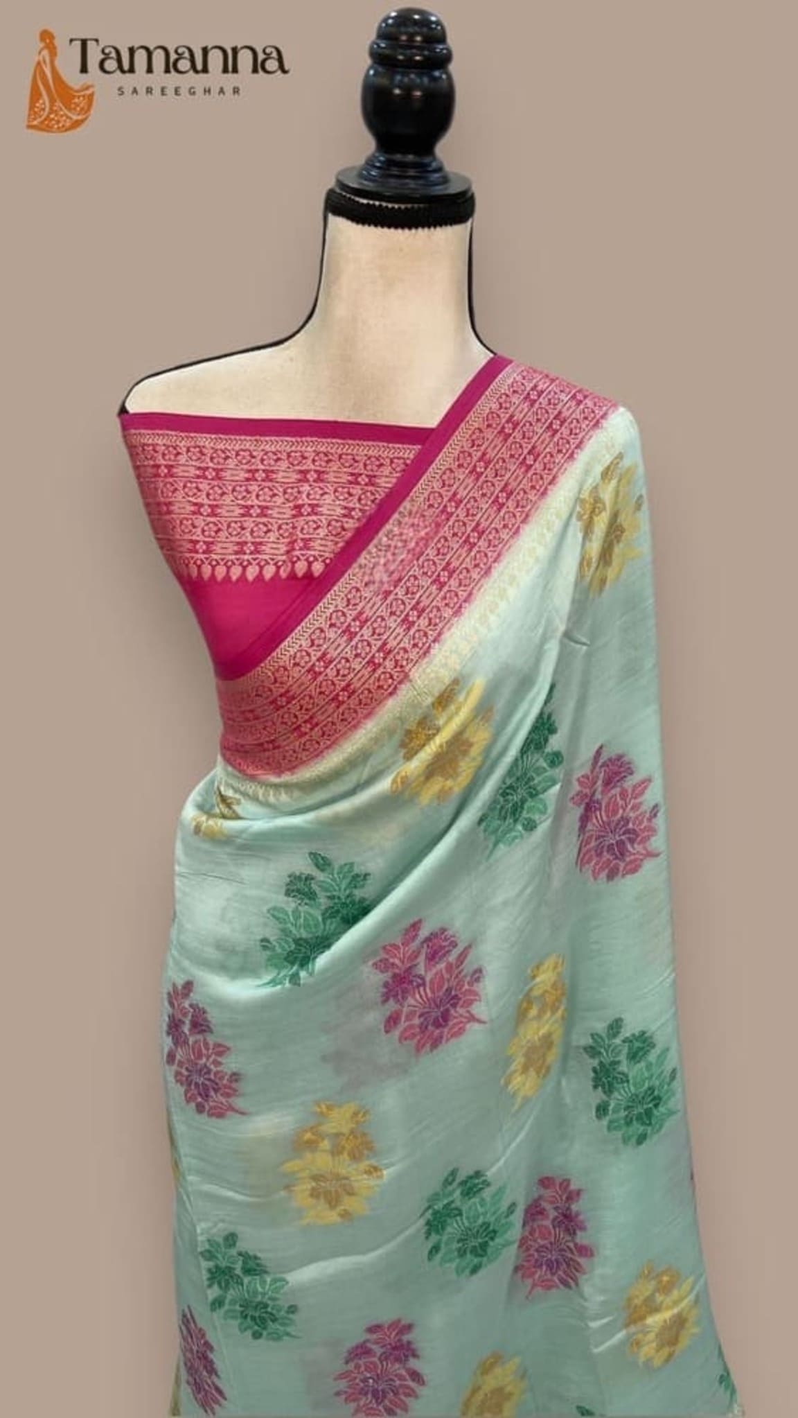 Sky blue saree on mannequin with pink border and floral motifs