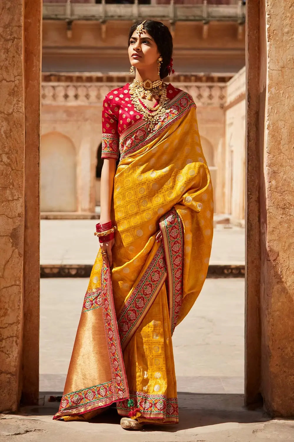 women wear yellow butter crepe banarasi saree with red border