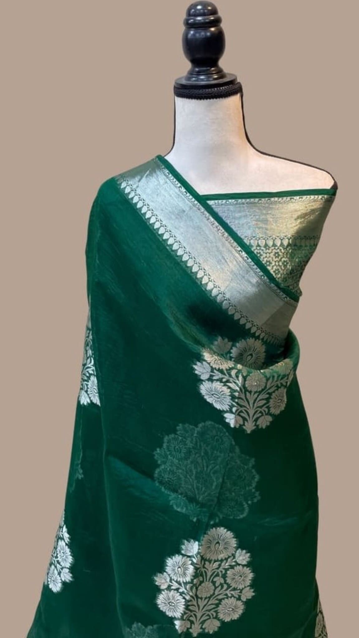 Dark green Banarasi saree with diagonal drape and off-white floral medallions