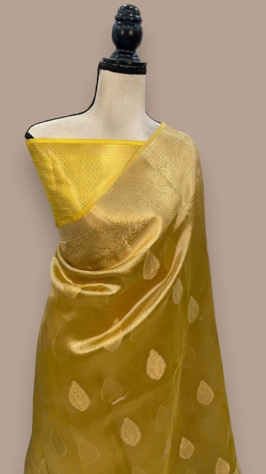 Golden yellow Banarasi tissue saree with gold motifs and satin-like sheen on drape