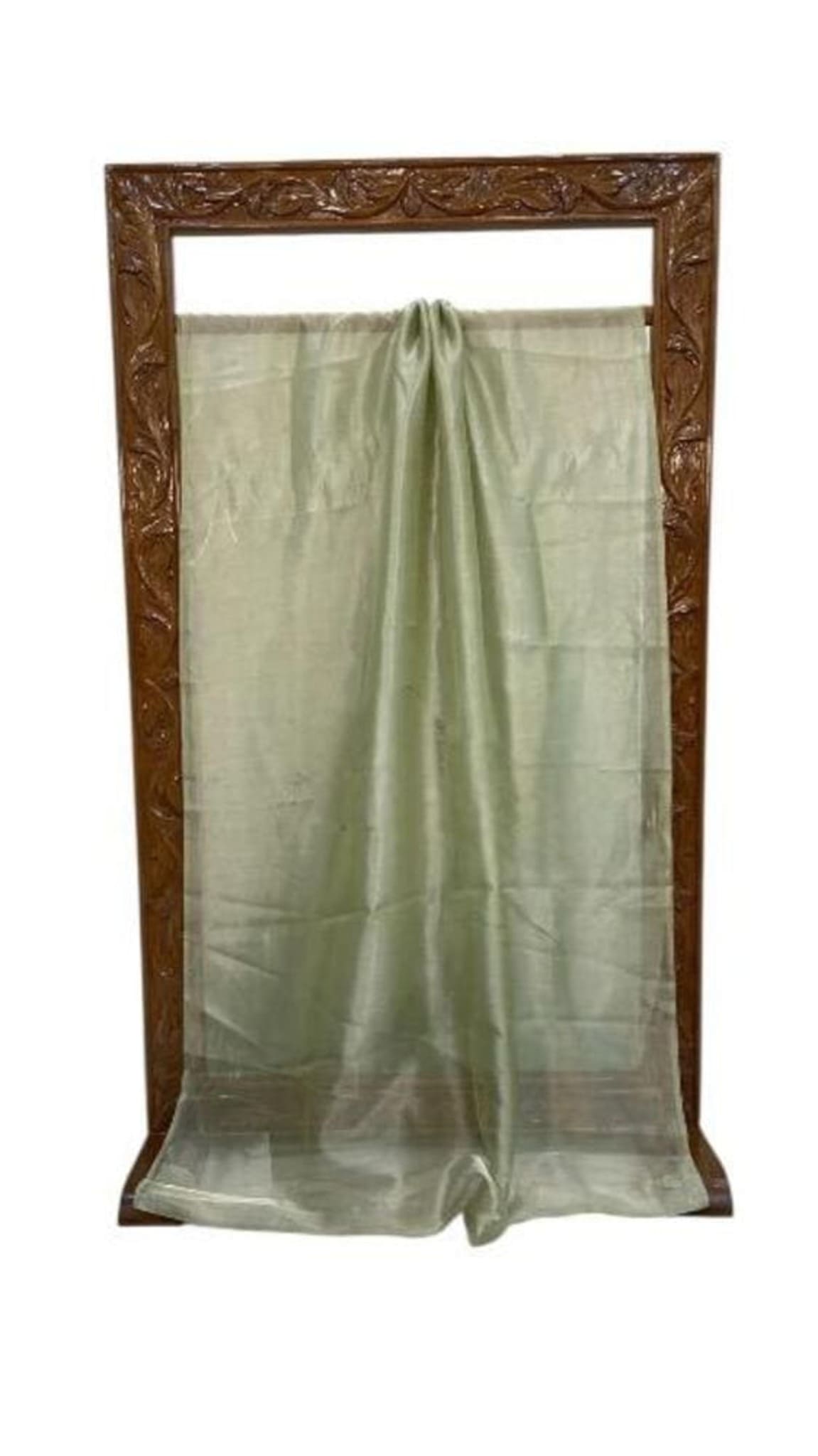 Light green saree hanging from display frame, pleated pallu fold and transparent edge