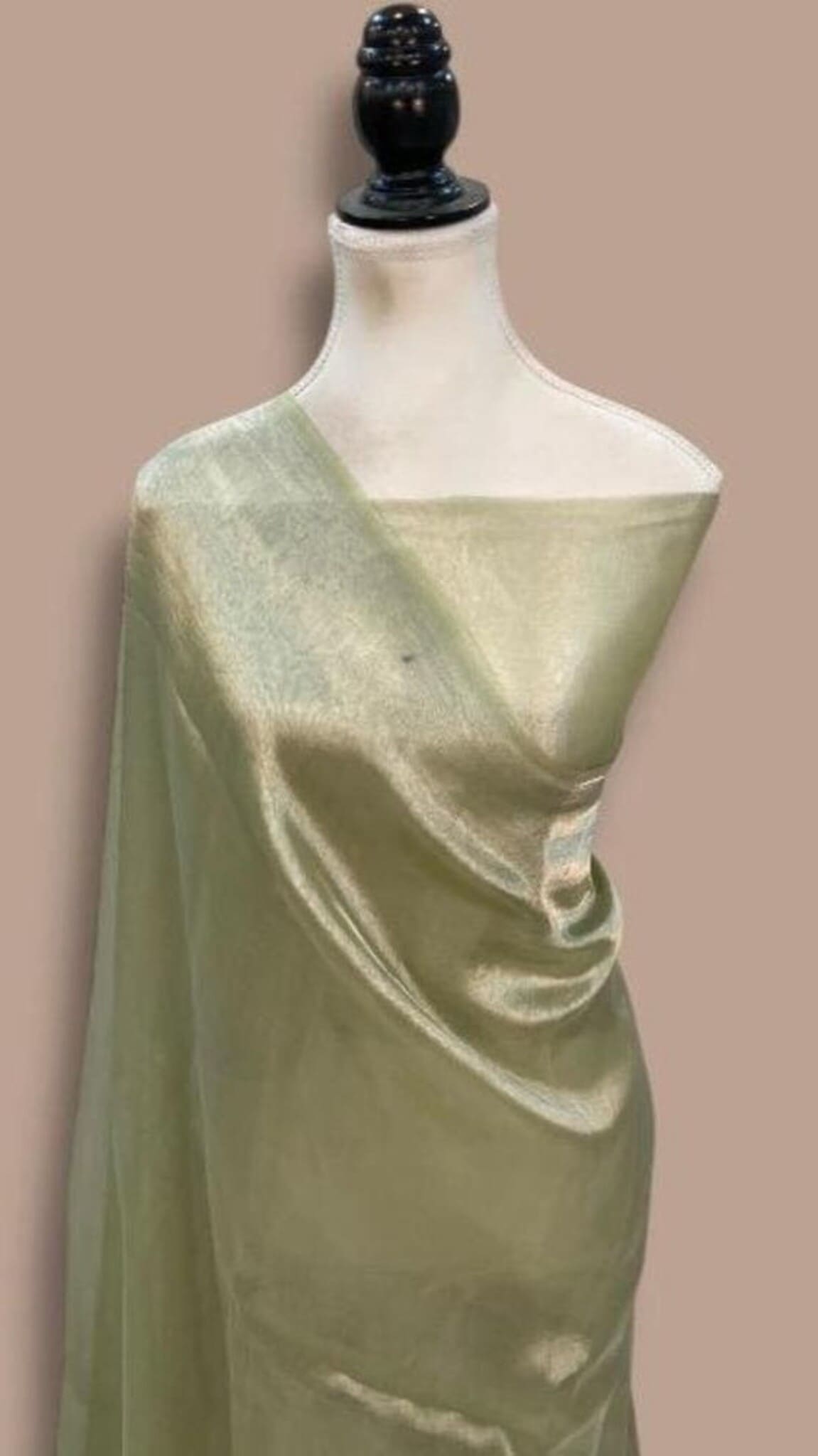 Light green saree with gold sheen, diagonal drape detail on mannequin