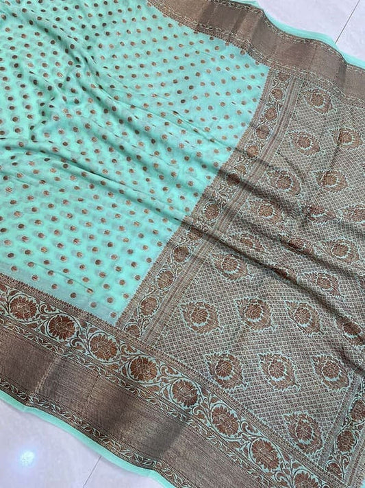 Turquoise saree fabric with dark gold woven border and ornate circular motifs
