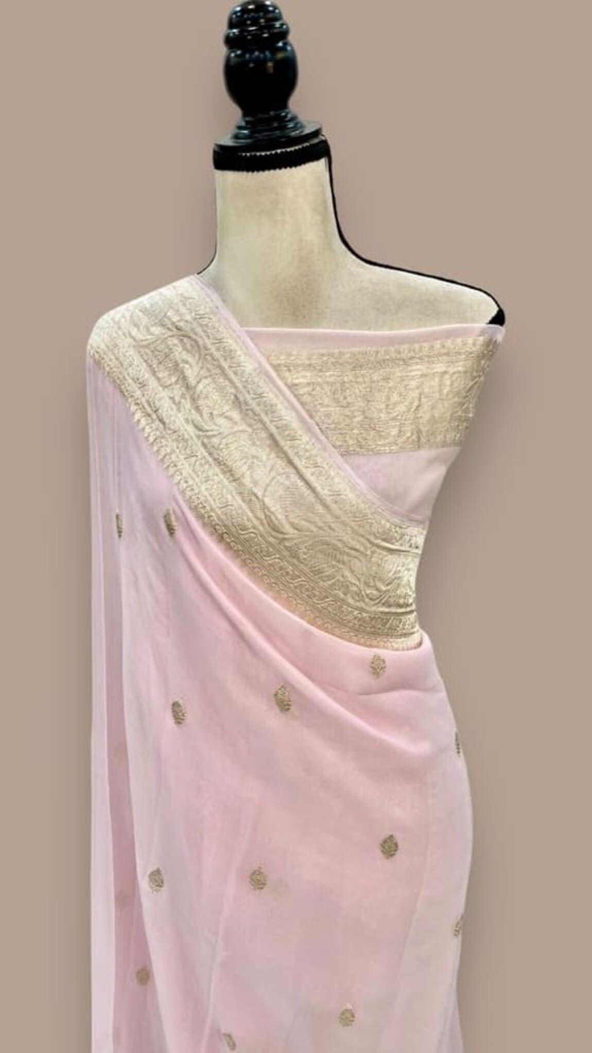 Light pink saree with gold zari border, diagonally draped pallu and dot motifs