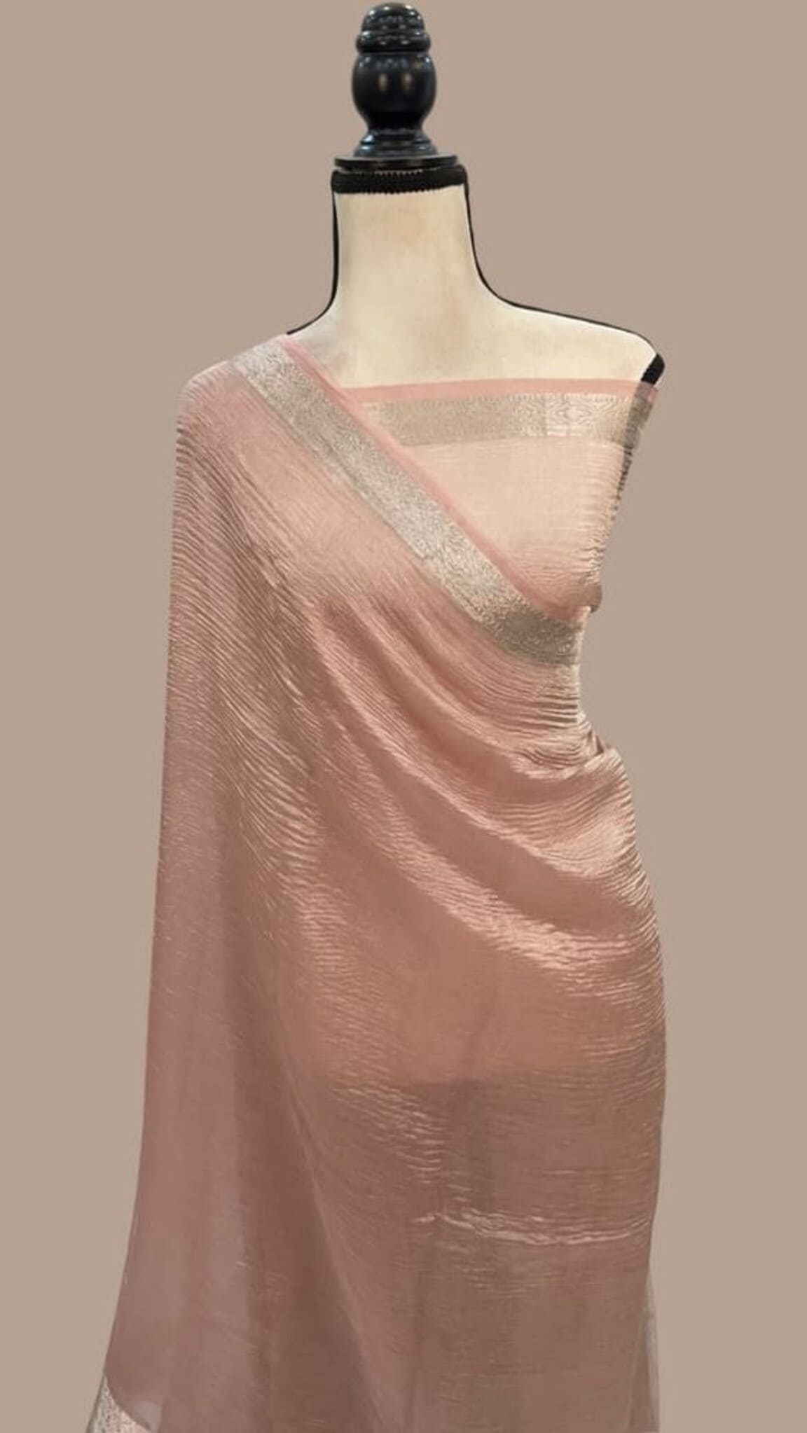 Baby pink tissue saree on mannequin, silver zari pallu and border