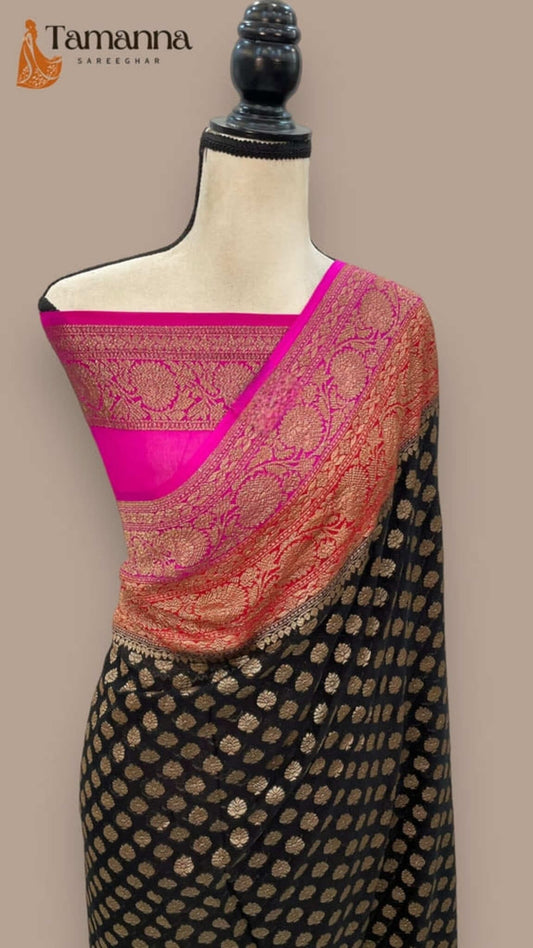 Black saree draped on mannequin with magenta panel and gold zari work