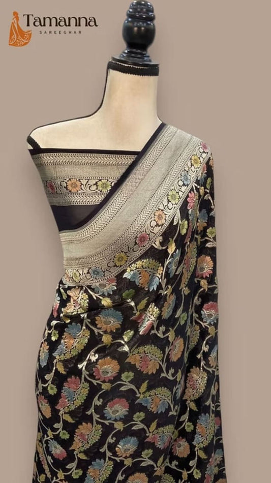 Black floral saree draped on mannequin, cream pallu border with gold zari motifs
