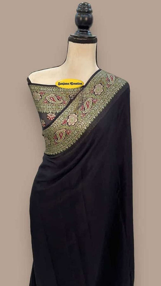 Black chiffon saree with green-gold patterned pallu and border on dress form
