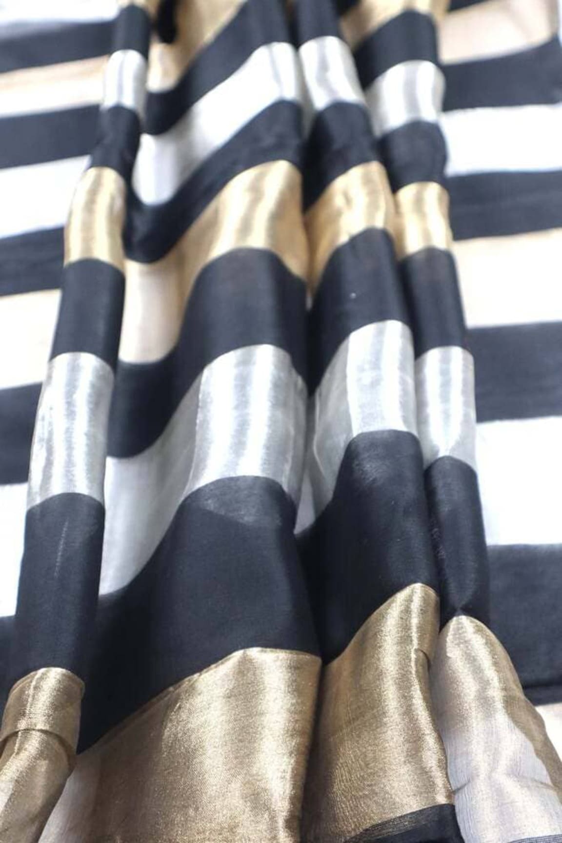 Detail of black-and-silver striped fabric with gold zari edge border