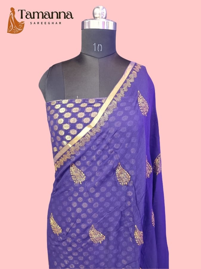 Blue chiffon saree on mannequin with gold leaf motif pattern and gold border