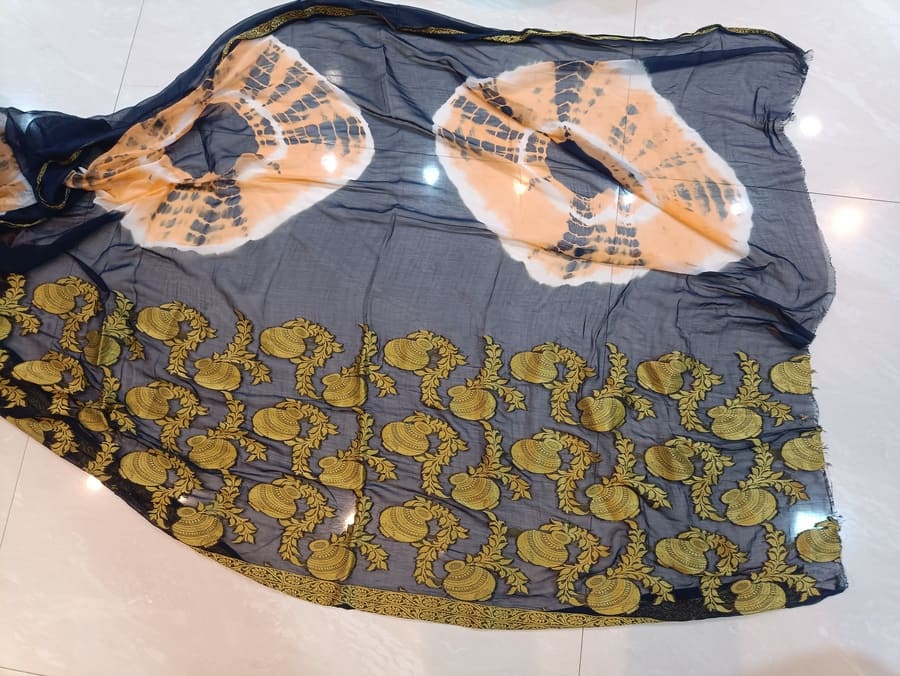 Dark blue printed chiffon saree with gold ornate border and large white-orange motifs