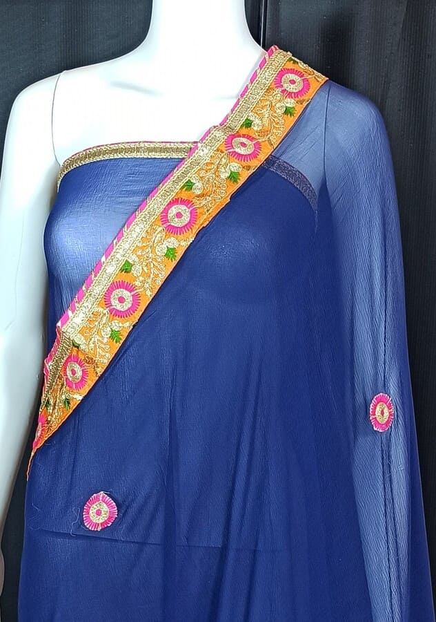 Blue chiffon saree with multicolor border, small round butti motifs, and draped pallu