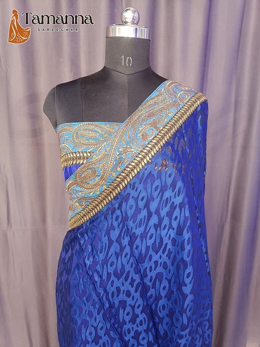 Blue printed saree with gold embellished border and teal pallu