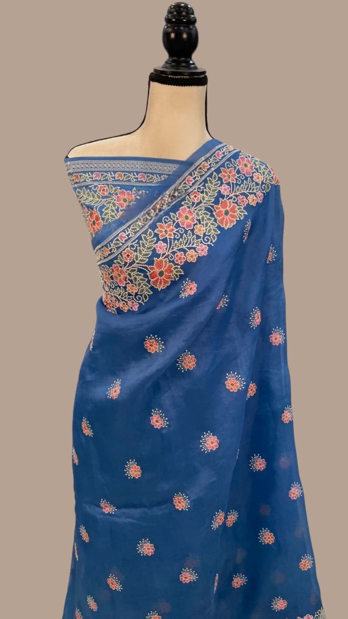 Blue saree draped on mannequin, scattered small floral prints with patterned border