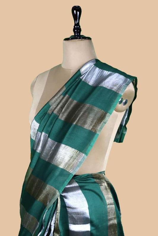Bottle green striped saree with silver sheen, drape around waist on mannequin.