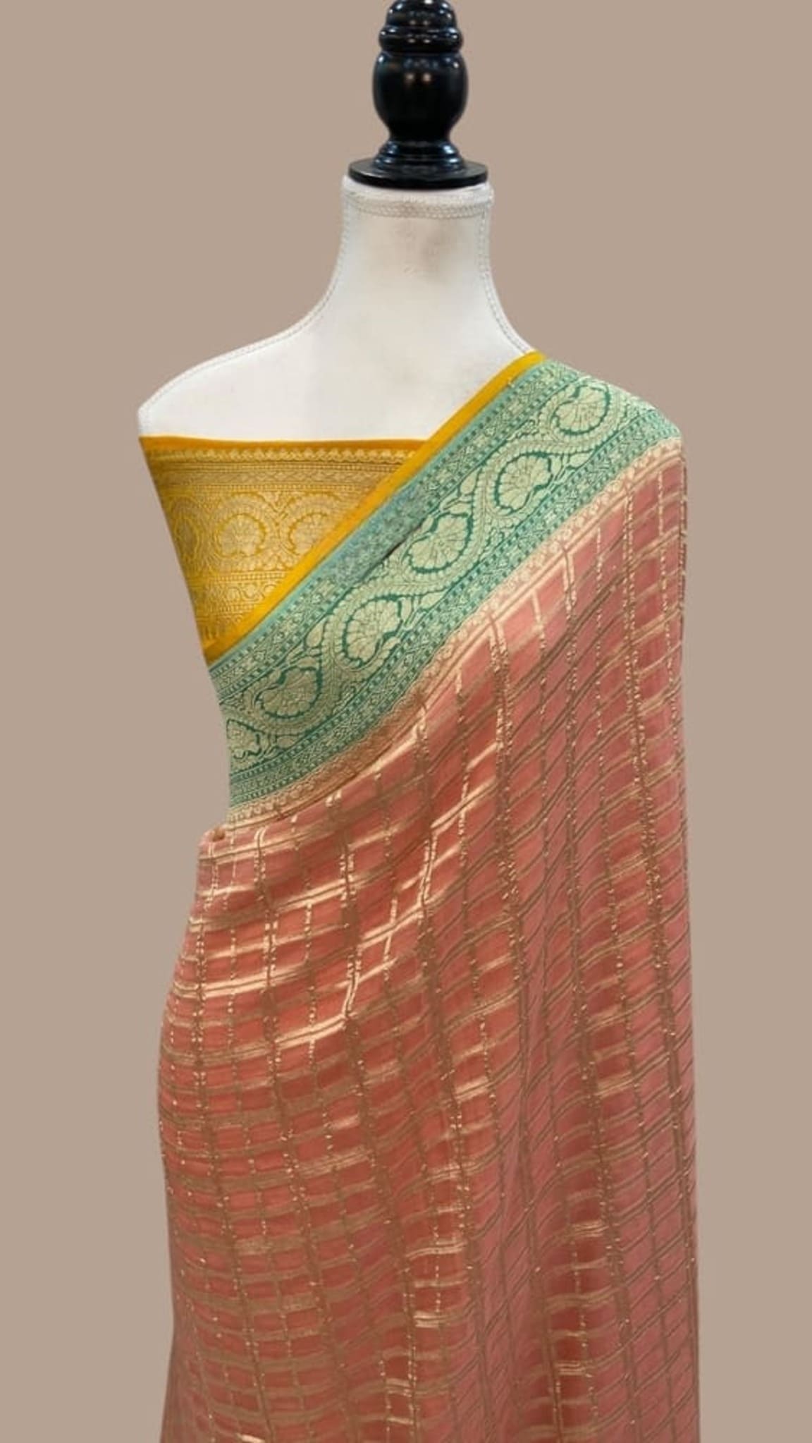 Brown georgette saree on mannequin with green pallu and gold border; woven grid texture