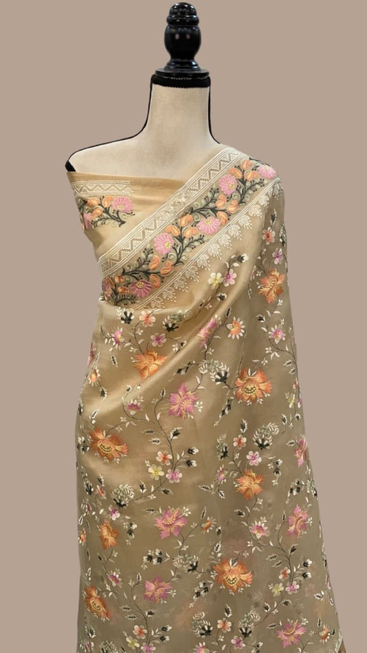 Beige organza saree with floral motif diagonal border, draped on mannequin