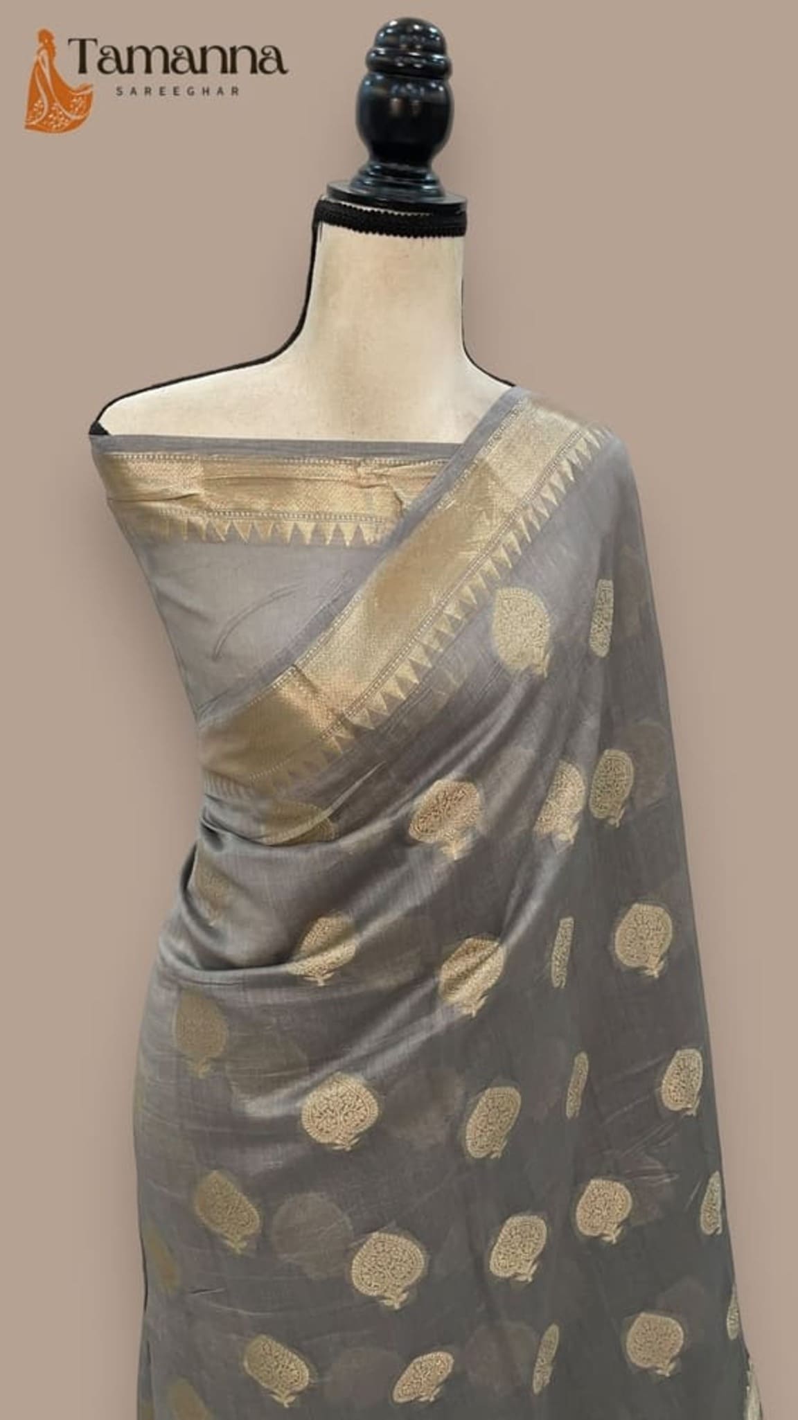 Carbon gray cotton saree on mannequin with wide gold zari border and dotted pattern