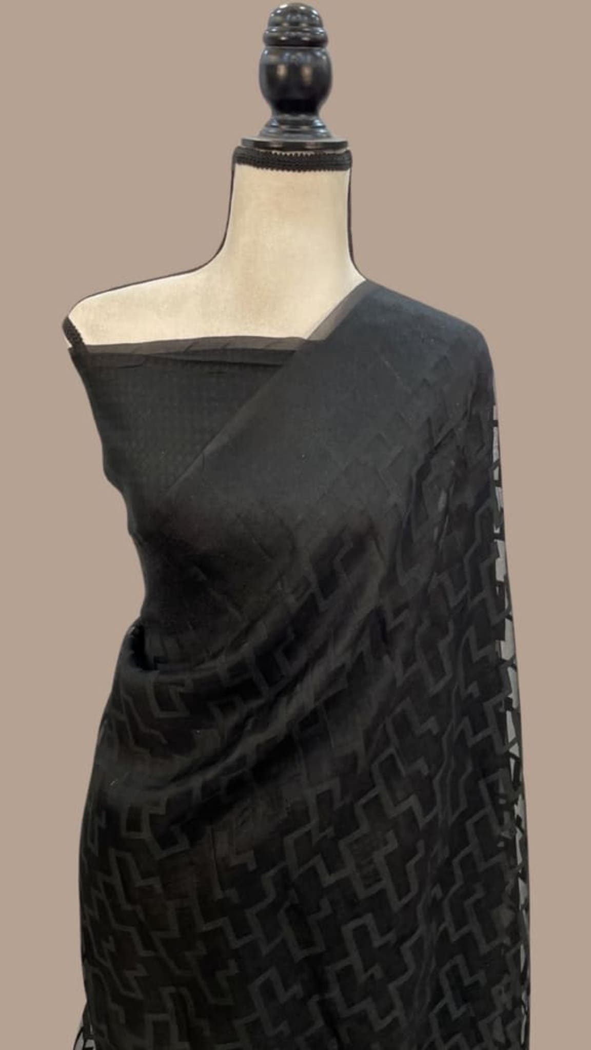Black Banarasi-style saree with geometric weave and pallu border on mannequin
