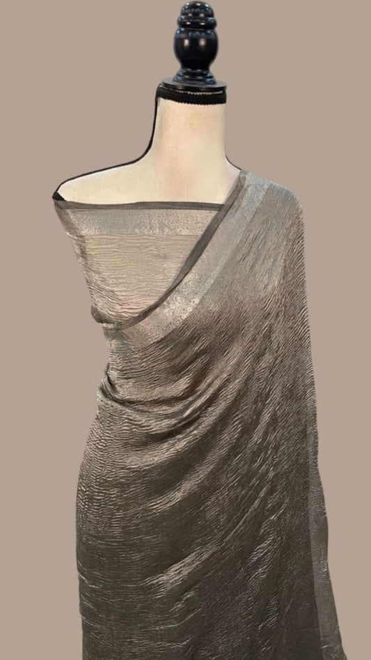 Grey crushed tissue saree with dark border and wide pallu drape on mannequin