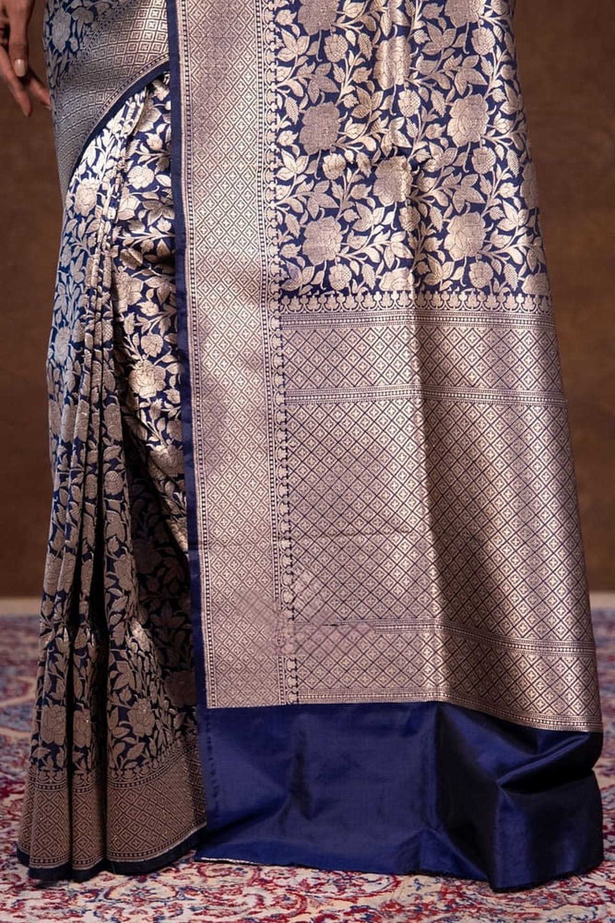 Navy-blue saree with long brocade panel, lattice motifs, and pleated fall