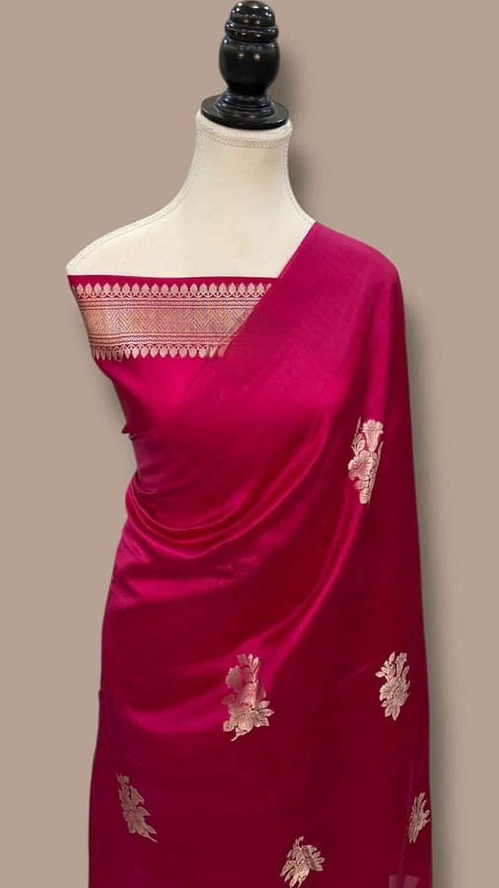 Cherry red Banarasi silk saree draped on mannequin with gold motif panel on pallu
