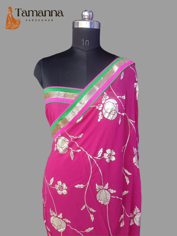 Magenta chiffon saree with white floral motifs and green striped border, displayed on mannequin.