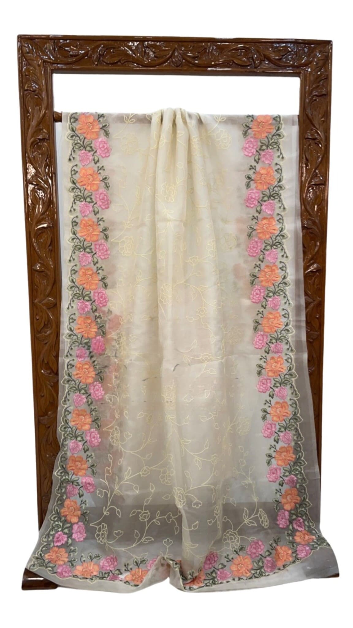 Cream organza saree with floral border and central motif, hung over frame