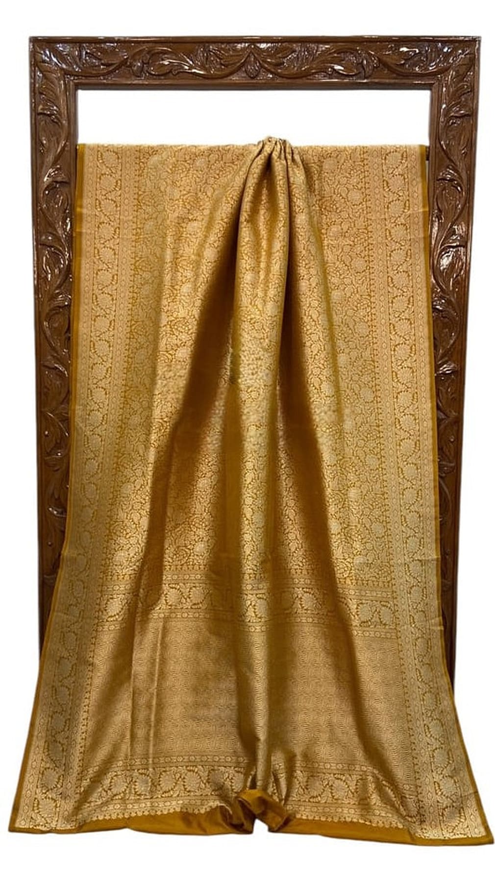 Gold silk saree with ornate woven motifs, pleated center, shown on display
