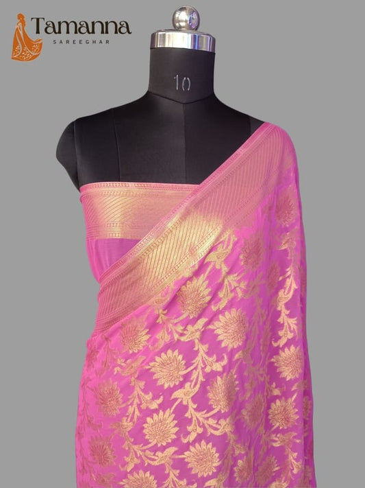 Pink chiffon saree with gold zari border and floral motifs, draped on mannequin