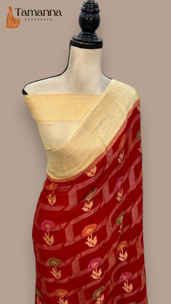 Red saree with cream border, gold vine motifs, and zari-style woven pattern