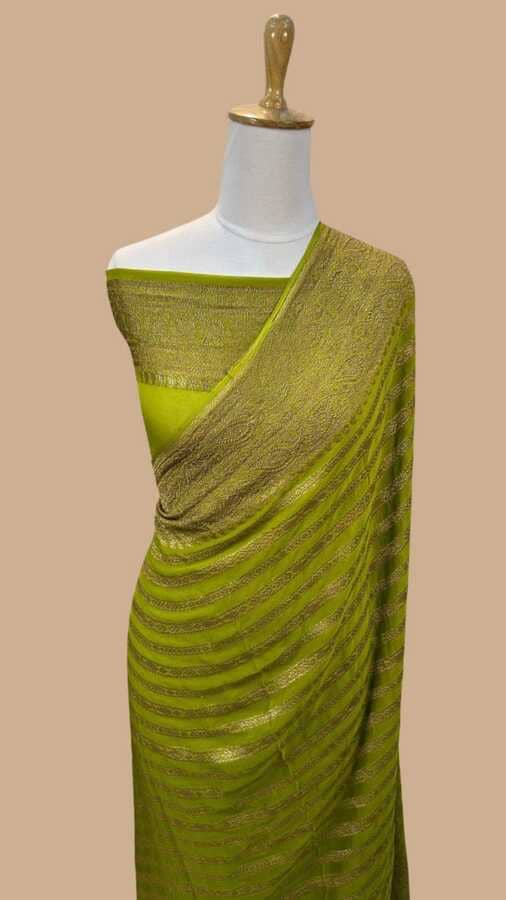 Green silk saree with gold zari border and woven pattern draped on mannequin