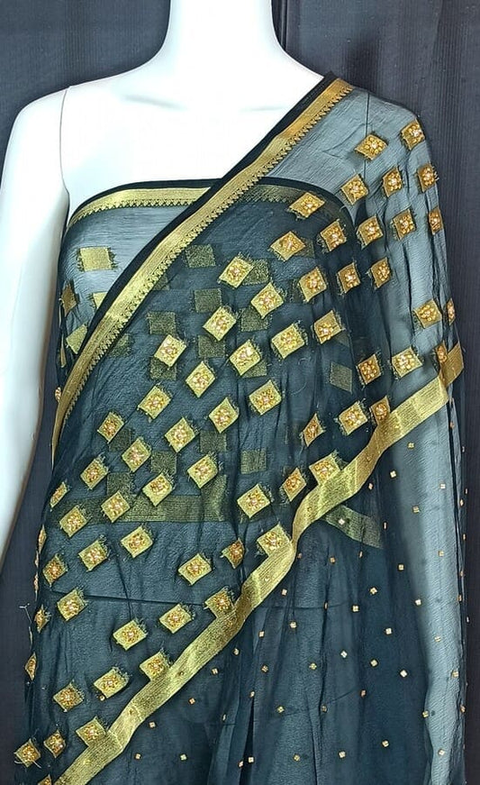 Dark chiffon saree with gold zari diamond motifs and gold border, draped on mannequin