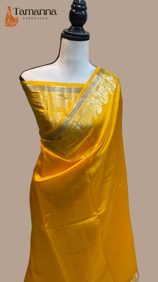 Warm yellow silk Banarasi saree with ornate silver-gold border and pallu