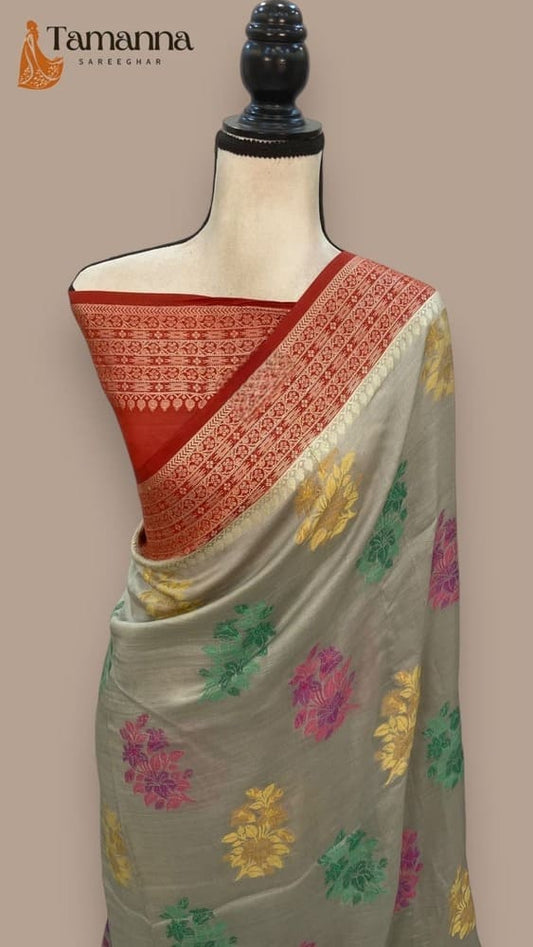 Grey crepe saree with red border and multicolor floral motifs, draped on mannequin