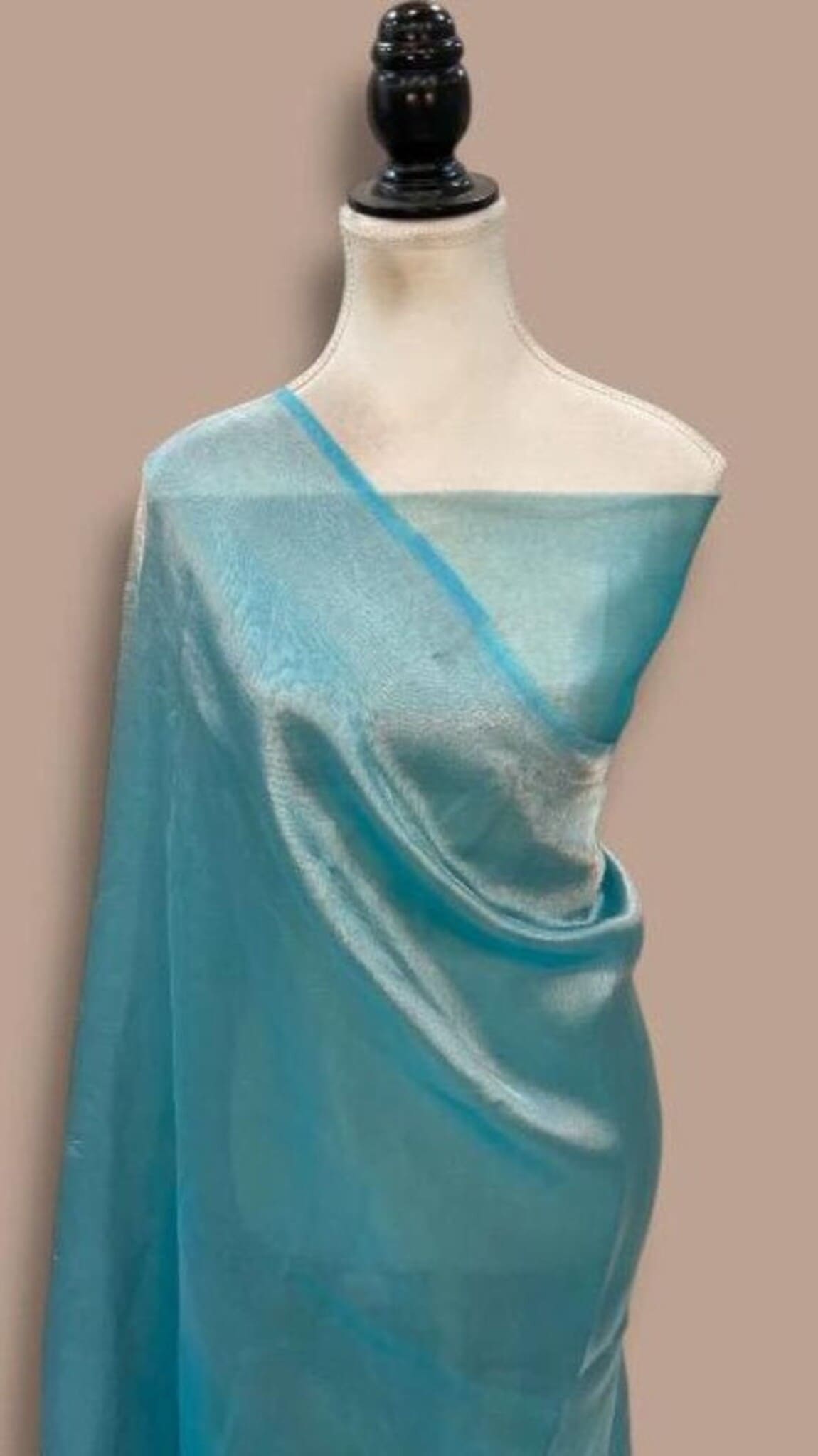 Teal Banarasi saree on mannequin with bright blue pallu and flowing pleats