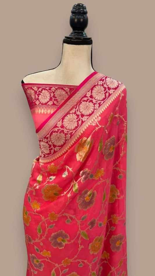 Pink saree on mannequin, red-pink pallu with gold floral vines and zari border