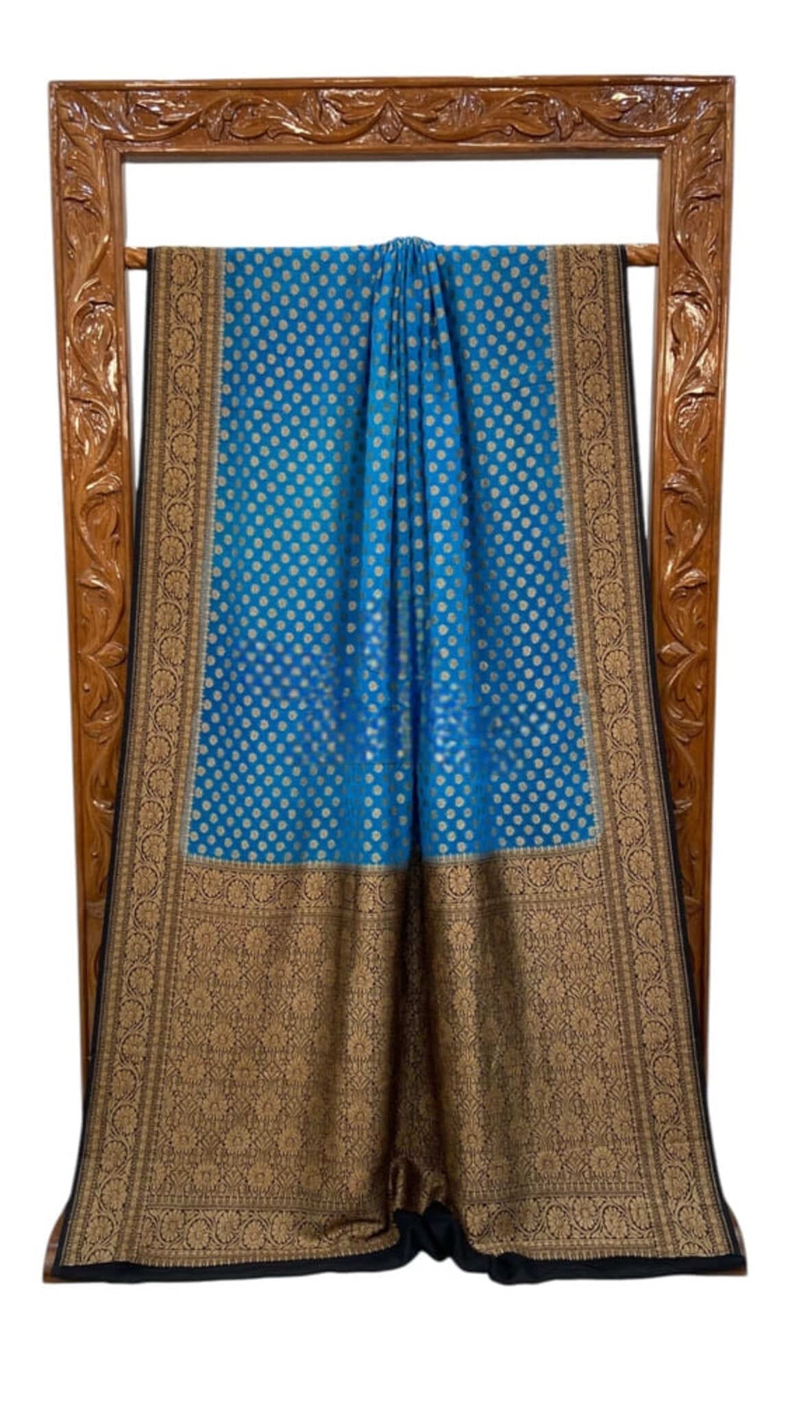 Blue saree draped flat with antique gold zari detailing and dot motif weave