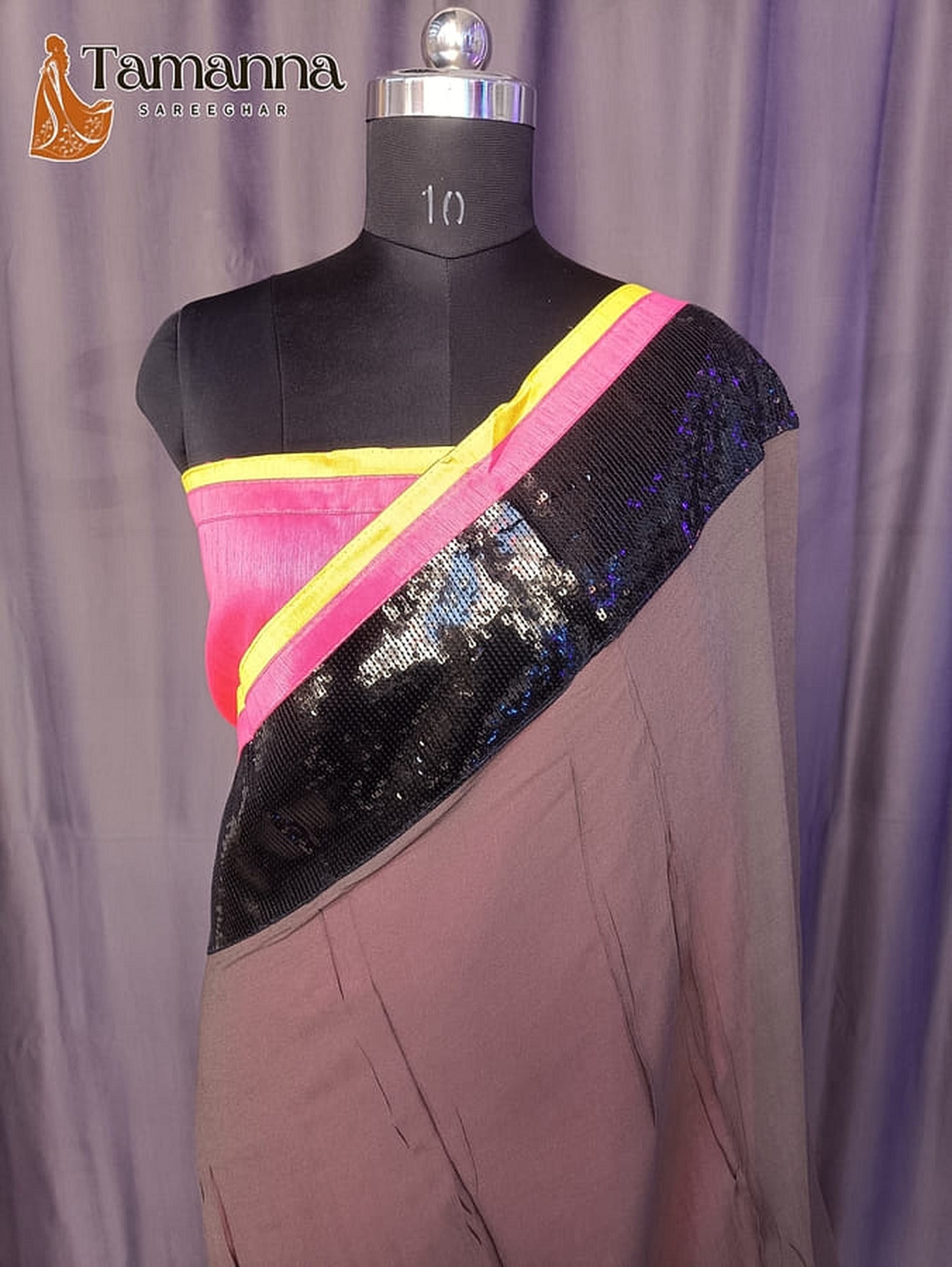 Grey saree on mannequin with diagonal dark sequined pallu and bright pink-yellow border