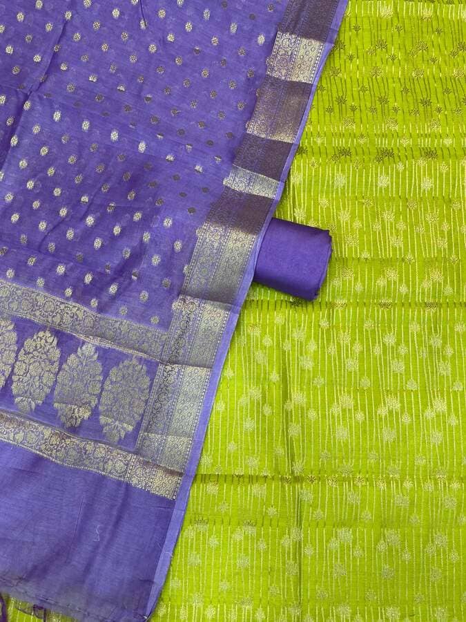 Purple fabric detail with dotted motifs and wide silver-gold border on green fabric