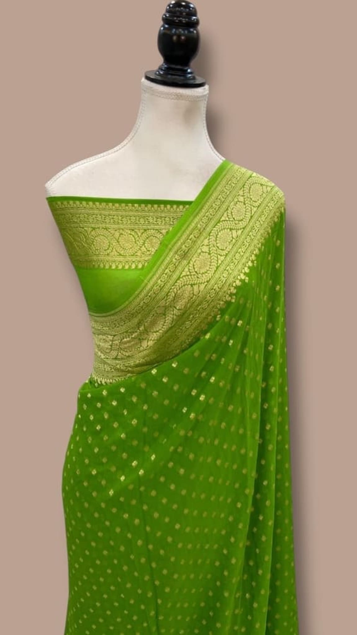 Green saree on mannequin with gold zari pallu and small dot motifs